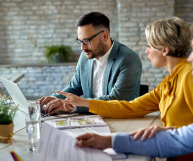 Real estate agent using laptop while having a meeting with a cou